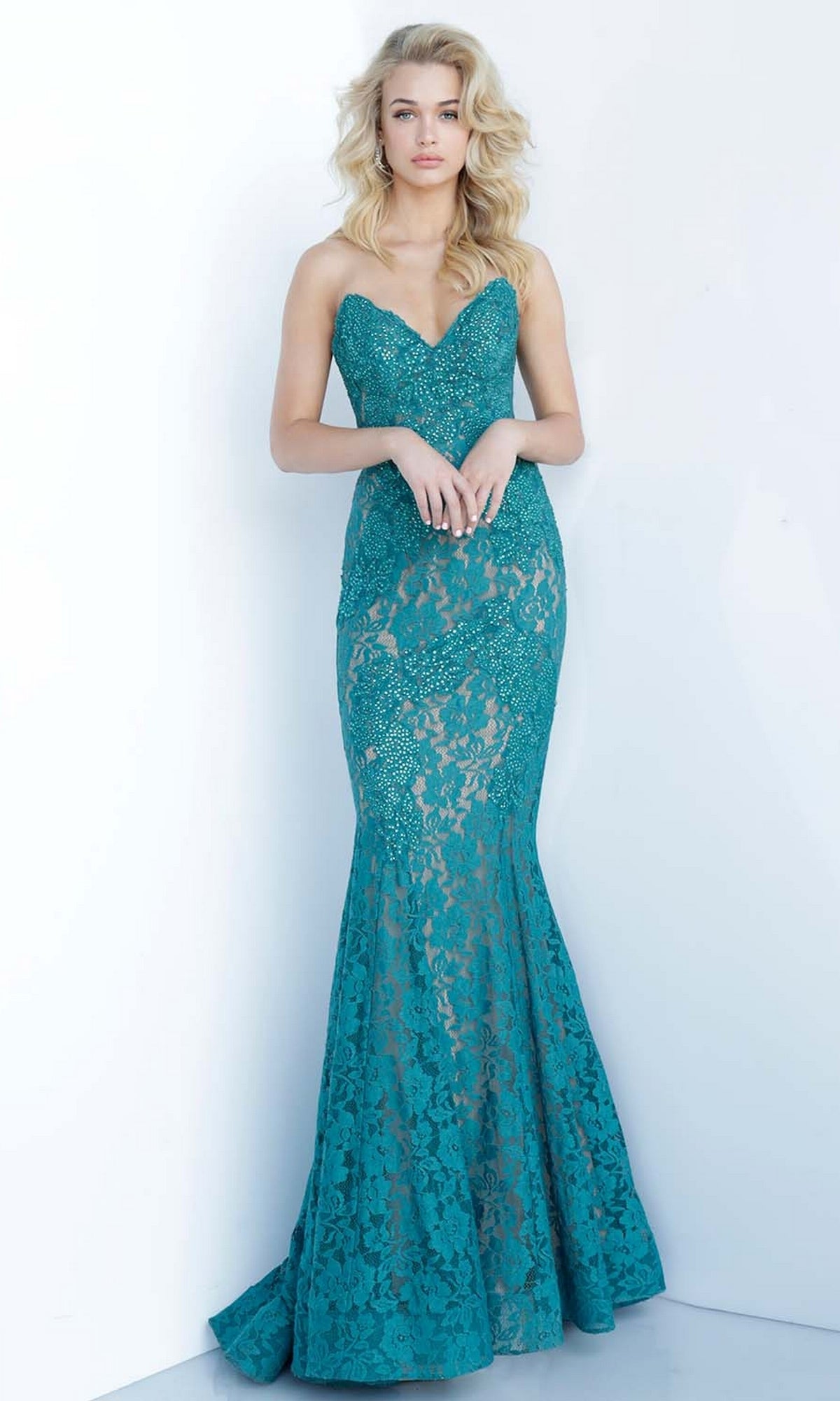 A woman stands against a plain white background wearing the Long Prom Dress 37334 by Jovani—a strapless teal lace gown with a sweetheart neckline and mermaid silhouette.